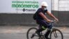 Un trabajador pasa en bicicleta junto a un letrero de la empresa venezolana de fertilizantes Monómeros, en Barranquilla, Colombia, el 9 de octubre de 2021.