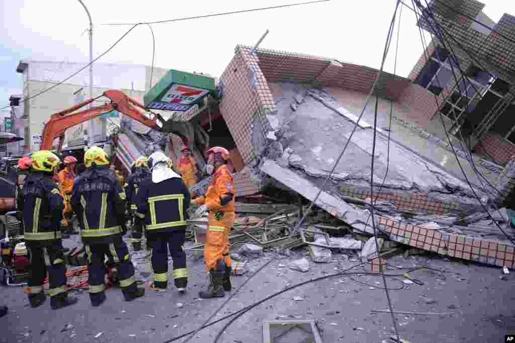 In this photo provided by Hualien City Government, firefighters are seen at a collapsed building during a rescue operation following an earthquake in Yuli township, Hualien County, eastern Taiwan.