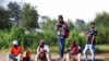 FILE - Job seekers wait beside a road for casual work offered by passing motorists in Eikenhof, south of Johannesburg, South Africa, March 3, 2022.