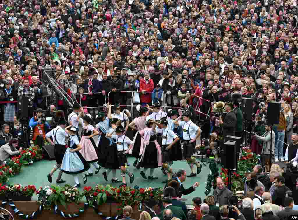 Visitors watch a traditional dancing chorus during the brass music concert at the Theresienwiese Oktoberfest fair grounds in Munich, southern Germany.