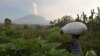 Seorang petani di Desa Sidemen, Karangasem, Bali, membawa sekantong pupuk saat erupsi Gunung Agung, 6 Desember 2017. (Foto: Antara/Nyoman Budhiana via REUTERS)