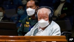 Khieu Samphan, right, the former head of state for the Khmer Rouge, sits in a courtroom during a hearing at the U.N.-backed war crimes tribunal in Phnom Penh, Cambodia, Sept. 22, 2022. (Nhet Sok Heng/Extraordinary Chambers in the Courts of Cambodia via AP)