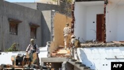 FILE - Members of the "444 Brigade" affiliated with Libya's Ministry of Defence man positions in the area of an overnight gunbattle in Tripoli's suburb of Ain Zara, on July 22, 2022.