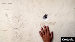 Agujero de bala en una pared situada en un lugar donde juegan niños del Bajo Aguán, en Honduras.