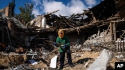 19일 우크라이나 북동부 하르키우 주 이지움 시민이 파괴된 학교 주변에서 땔감을 찾고 있다. (자료사진)