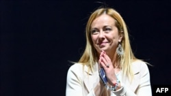 Brothers of Italy party leader Giorgia Meloni acknowledges applause after she delivered a speech on stage, Sept. 22, 2022, during a joint rally of Italy's right-wing parties Brothers of Italy, the League and Forza Italia, at Piazza del Popolo in Rome, ahe