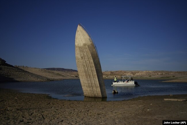 A formerly sunken boat, upright along the shoreline at the Lake Mead National Recreation Area, June 10, 2022, (AP Photo/John Locher, File)