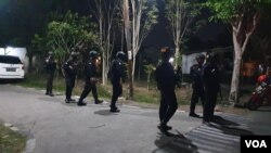 Akses menuju lokasi kejadian ledakan di Asrama Polisi Brimob Sukoharjo dijaga ketat aparat bersenjata lengkap, Minggu malam (25/9). (Foto: VOA/ Yudha Satriawan)