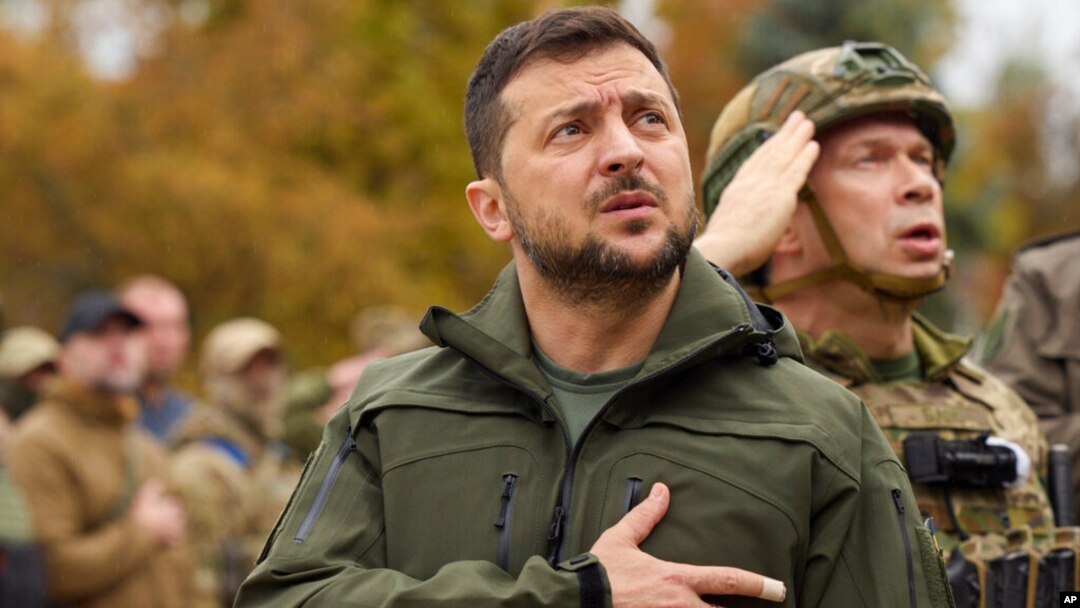 Tổng thống Ukraine Volodymyr Zelenskyy và binh sĩ hát quốc ca, chào cờ khi thăm thành phố Izium, vùng Kharkiv, Ukraine, 14/9/2022. 