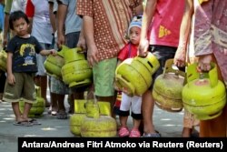 Warga membawa tabung gas saat antre membeli elpiji 3 kilogram di kawasan Mantrijeron Yogyakarta, (Foto: Antara/Andreas Fitri Atmoko via Reuters)