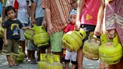 FILE - Warga membawa tabung gas saat antre membeli elpiji 3 kilogram di kawasan Mantrijeron Yogyakarta, 25 Mei 2015. (Foto: Antara/Andreas Fitri Atmoko via Reuters)