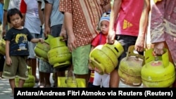 FILE - Warga membawa tabung gas saat antre membeli elpiji 3 kilogram di kawasan Mantrijeron Yogyakarta, 25 Mei 2015. (Foto: Antara/Andreas Fitri Atmoko via Reuters)