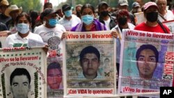 FILE - Marchers demand justice for the missing 43 Ayotzinapa students in Mexico City, Aug. 26, 2022. Mexican authorities have arrested a general and two other members of the army for alleged connection to the students' disappearance, the government said on Sept. 15, 2022.  