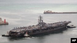 El portaaviones estadounidense USS Ronald Reagan sale de un puerto en Busan, Corea del Sur, el lunes 26 de septiembre de 2022.