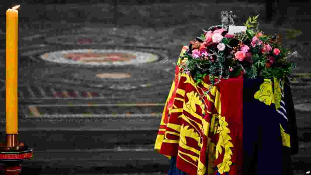 The coffin of Queen Elizabeth II, draped in the Royal Standard, is placed in Westminster Abbey in central London, for the funeral service, Sept. 19, 2022.