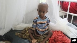 A malnourished child from southern Somalia sits on a bed at Banadir hospital in Mogadishu, Somalia, August 1, 2011