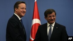 British Prime Minister David Cameron, left, and his Turkish counterpart, Ahmet Davutoglu, conclude a news conference in Ankara, Dec. 9, 2014. 