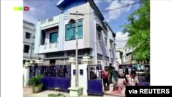 People walk out from a house believed to have been raided by security forces, in Mandalay, Myanmar, June 22, 2021 in this screen grab taken from a REUTERS TV video.