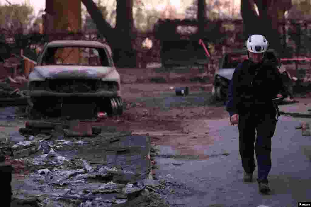 Jennifer McCullough from Marin County Search and Rescue inspects a burned property for hazards and remains during the Eaton fire in Altadena, California, Jan. 11, 2025. 