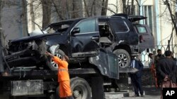 Personel keamanan Afghanistan memindahkan kendaraan yang rusak dari lokasi serangan bom mematikan di Kabul, Afghanistan, Selasa, 9 Februari 2021.