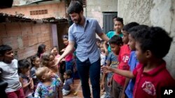 Roberto Patino greets children at a children's center in the La Vega neighborhood of Caracas, Venezuela, Aug. 26, 2018.