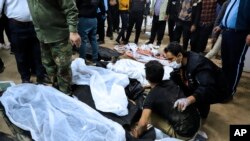 资料照片：一名男子坐在2024年1月3日伊朗克尔曼恐怖爆炸中丧生亲人的尸体旁边，另外一人在安慰他。（美联社照片）