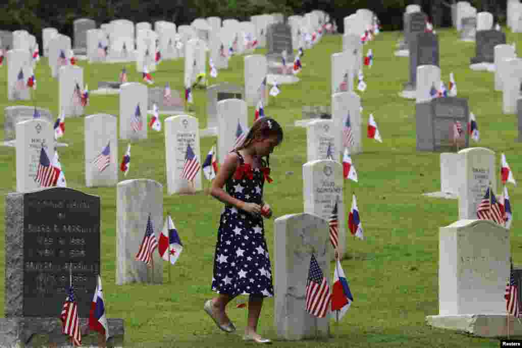 سابق فوجیوں کی یاد میں منائے گئے دن کے موقعے پر ایک لڑکی امریکی سیمٹری سے گزر رہی ہے