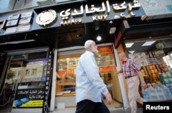 FILE - People walk past by a Syrian jewelry shop in Istanbul's Kucukcekmece district, Turkey, July 5, 2019.
