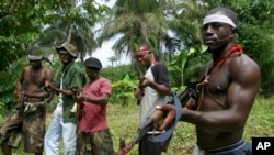 Des militants patrouillent à Okorota, près de Port Harcourt, Nigeria, le 25 juin 2004.