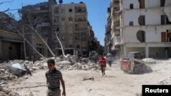 People walk on rubble of buildings damaged by what activists said was shelling by forces loyal to Syria's President Bashar al-Assad in Aleppo's Bustan al-Qasr district, Sept. 9, 2013. 