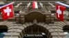 FILE - National flags of Switzerland fly over the entrance of the headquarters of Swiss bank Credit Suisse in Zurich July 31, 2014.