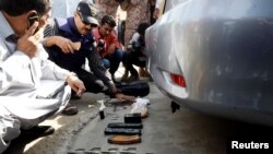 Members of the bomb disposal unit, checking the explosives recovered from a bag, after an attack on the Chinese consulate, in Karachi, Pakistan, Nov. 23, 2018.