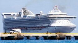 FILE - An ambulance waits at a dock upon the arrival of the cruise ship 'Grand Princess' as it arrives in the port of Mahaual, Mexico, March 26, 2007.