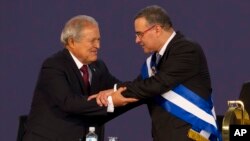 ARCHIVO - El presidente de El Salvador, Salvador Sánchez Cerén, abraza a su sucesor en el cargo, Mauricio Funes, durante su toma de posesión, en San Salvador, en junio de 2014.
