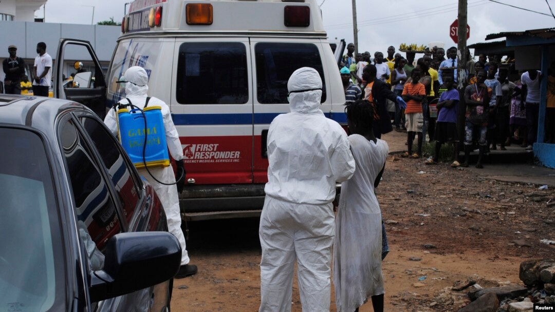 Petugas kesehatan membawa seorang perempuan yang diduga tertular Ebola ke sebuah ambulans di Monrovia, Liberia (15/9). Militer AS akan membangun pusat komando misi pemberantasan Ebola di Monrovia.