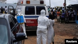 Petugas kesehatan membawa seorang perempuan yang diduga tertular Ebola ke sebuah ambulans di Monrovia, Liberia (15/9). Militer AS akan membangun pusat komando misi pemberantasan Ebola di Monrovia.