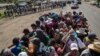 Migrants travel on a truck as others in the back wait in a line for a ride on the road that connects Tapanatepec with Niltepec, Mexico, as a caravan of Central Americans continues its slow march toward the U.S. border, Oct. 29, 2018.