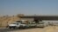 FILE - Iraqi security forces in uniforms and plainclothes head to Baghdad in the main road between Baghdad and Mosul, a day after fighters from the Islamic State of Iraq and the Levant took control of much of Mosul,  June 11, 2014.