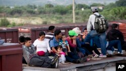 FILE - Central American migrants ride a freight train during their journey toward the U.S.-Mexico border in Ixtepec, Mexico, July 12, 2014. 