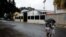FILE - People walk near a factory where Aragua State police officers killed four men execution-style in Maracay, Venezuela, Aug. 20, 2015. 