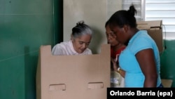 Citizens cast their votes for the general and local elections at a polling station in Santo Domingo, Dominican Republic, May 15, 2016. 