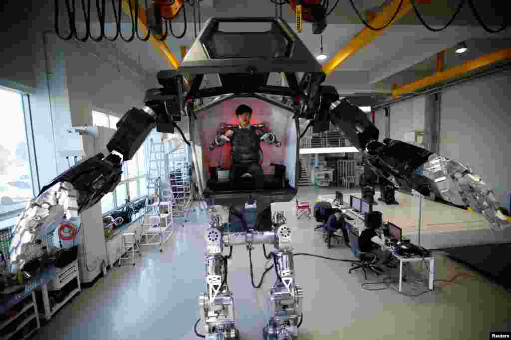 An employee controls the arms of a manned biped walking robot &quot;METHOD-2&quot; during a demonstration in Gunpo, South Korea.