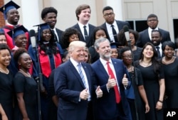 El presidente Donald Trump y el decano de la Universidad Liberty, en Lynchburg, Virginia, posan con el coro de la escuela durante la ceremonia de graduación de la Clase 2017. Mayo 13, 2017.