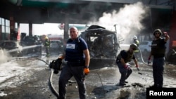 Expertos en explosivos revisan los escombros de una gasolinera atacada en la ciudad de Ashdod, en Israel.