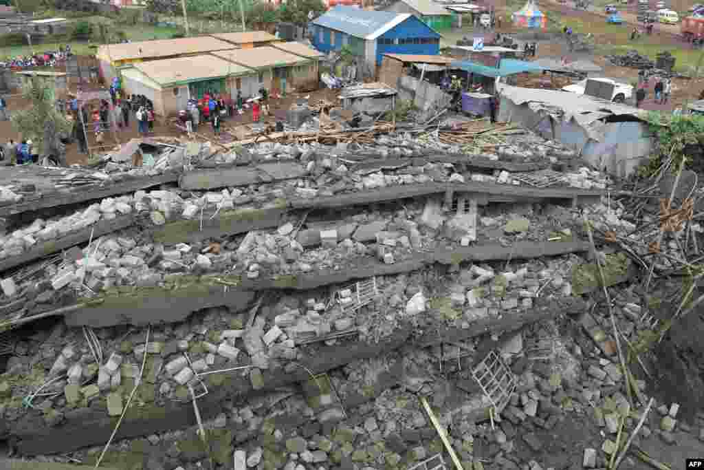 People look at the devastation after a six-story building under construction collapsed, killing two people, at the Joyland area in Ruaka, in Kiambu county, Kenya.