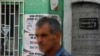 Seorang pria berjalan melewati sejumlah poster di dinding yang bertuliskan "Tidak ada kata menyerah. Identitas Serbia tetap ada" di wilayah Mitrovica Utara, Kosovo, pada 1 September 2022. (Foto: Reuters/Ognen Teofilovski)
