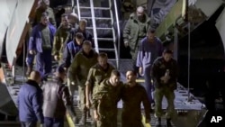 ARHIVA - Ruski zarobljenici izlaze iz ruskog vojnog aviona nakon puštanja na slobodu (Foto: AP/Russian Defense Ministry Press Service)