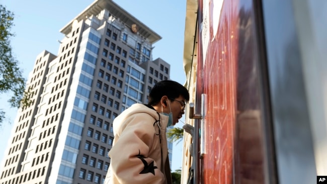 FILE - A man gets swabbed for COVID test near a building of the Peking University in Beijing, Wednesday, Nov. 16, 2022. (AP Photo/Ng Han Guan)