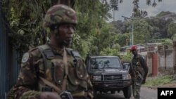 FILE: Democratic Republic of Congo (DRC) and Kenyan soldiers stand guard at the East African Community (EAC) headquarters in Goma, eastern DRC, on November 16, 2022.