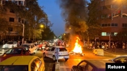 Una motocicleta de la policía arde en una calle de Teherán durante una protesta por la muerte de una joven arrestada por la policía de la moral, el 19 de septiembre de 2022.